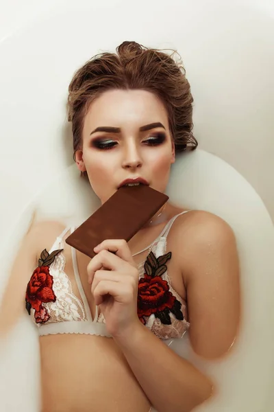 Bella ragazza in lingerie di pizzo bianco prende un bagno con latte e ea — Foto Stock