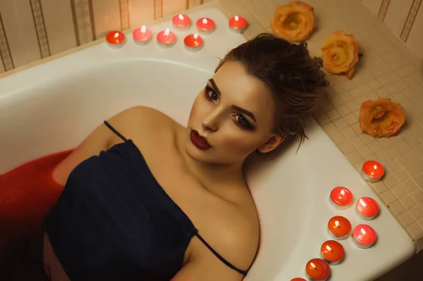 Elegantní mladá dáma s dokonalým make-upem bere koupel s červeným wat — Stock fotografie