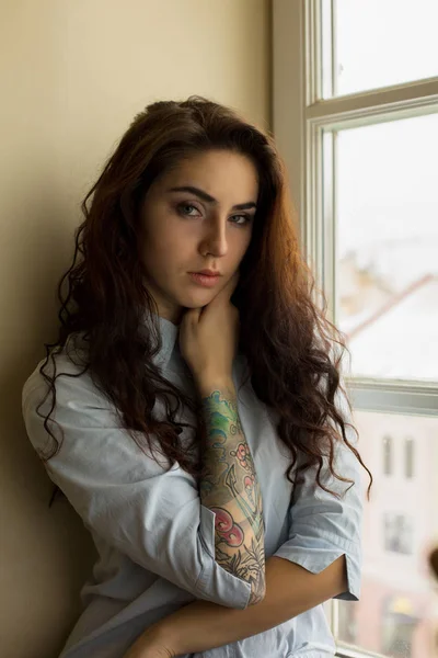 Καταπληκτικό μελαχρινή γυναίκα με σγουρά μαλλιά και ένα τατουάζ στο χέρι — Φωτογραφία Αρχείου