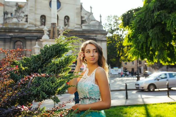 Tierna modelo rubia en vestido de encaje posando en los rayos del sol en el parque — Foto de Stock