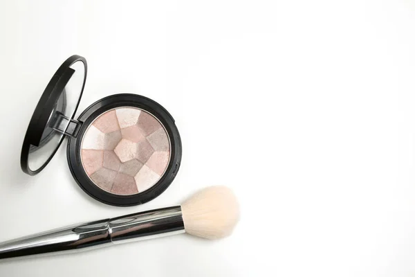 Pressed highlighter with makeup brush on a white background — Stock Photo, Image