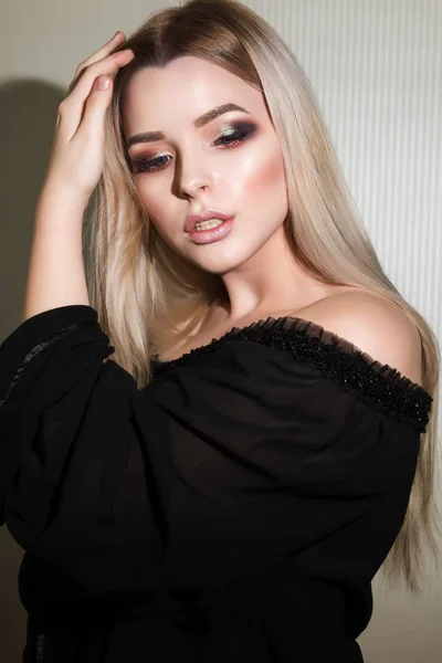 Schattige blonde vrouw met een perfecte make-up die zich voordeed op de witte wa — Stockfoto