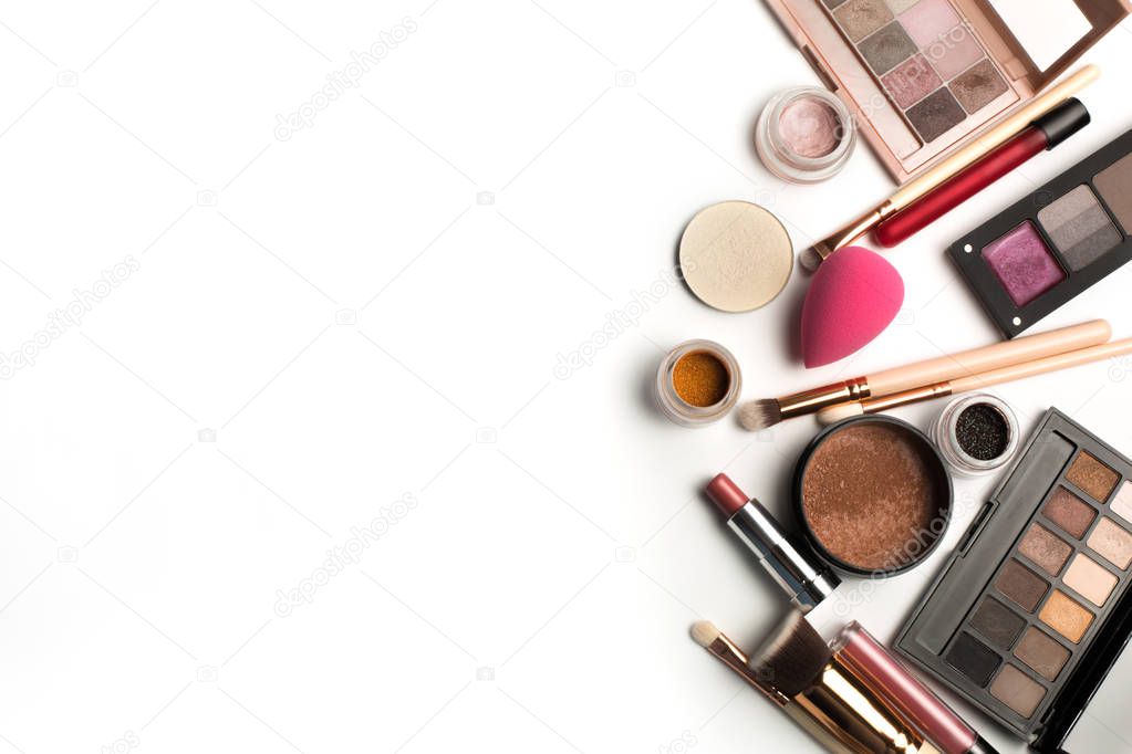 Flat lay of makeup palettes, eyeshadow pigments and lip gloss. S