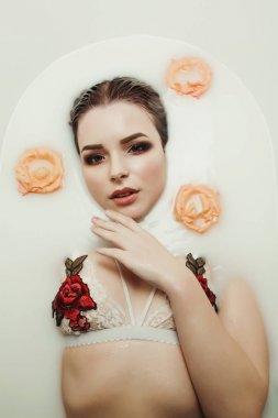 Sevimli sarışın Bayan parlak makyaj ile alır bir banyo süt ile bir