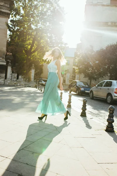 Prächtige blonde Frau in modischem Kleid, die durch die Stadt spaziert — Stockfoto