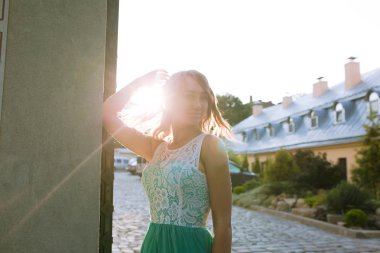 Rüzgar, dalgalı saçlı şık sarışın kadın güneş ışınları poz 