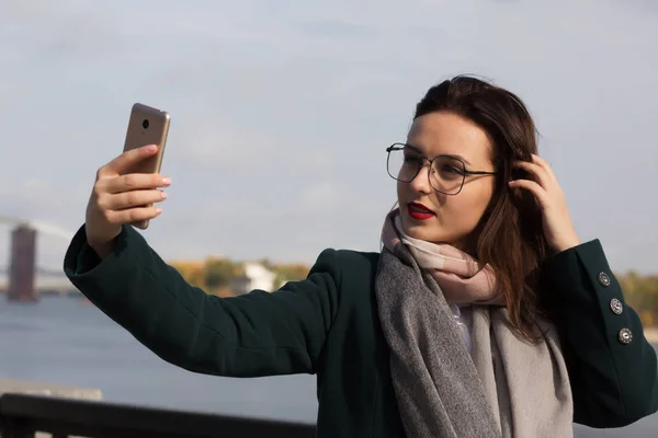 Pretty brunette girl tourist taking a selfie photo on a coast of — Stock Photo, Image