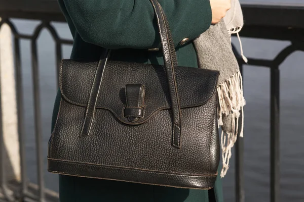 Mulher vestida na moda em casaco verde usando bolsa de couro preto — Fotografia de Stock