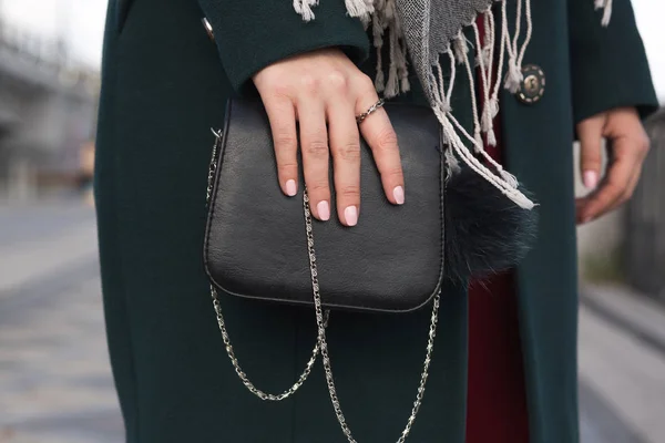 Femme habillée à la mode en manteau vert posant avec leathe noire — Photo