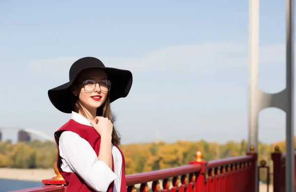 Stylish brunette model wearing red costume, hat and glasses, pos — Stock Photo, Image