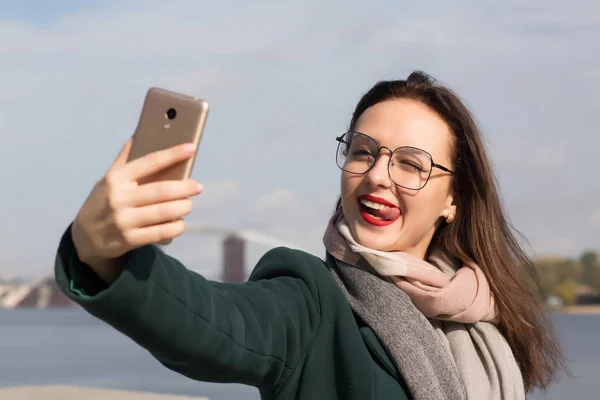 Emotionaalinen brunette tyttö turisti ottaa selfie kuva rannikolla — kuvapankkivalokuva
