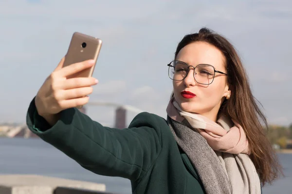 Adorable brunette girl tourist taking a selfie photo on a coast — Stock Photo, Image