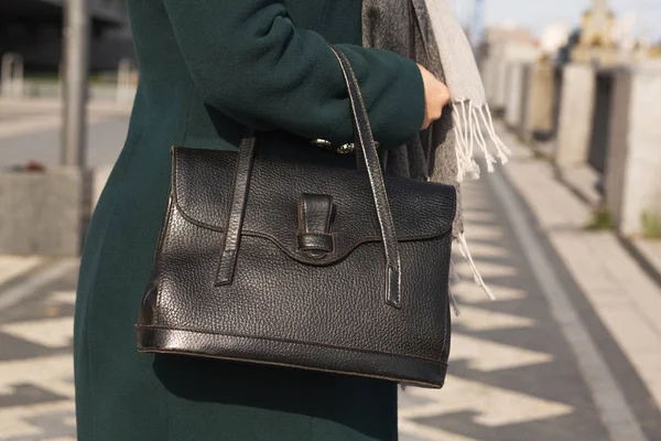 Mulher vestida elegante em casaco verde usando bolsa de couro preto — Fotografia de Stock