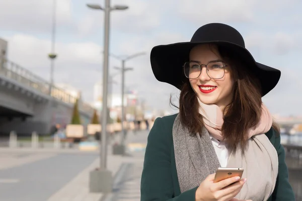 Senyum ceria gadis berambut cokelat di kacamata dan topi berpakaian fas — Stok Foto
