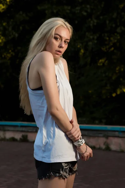 Vacker blond tjej med långt hår, klädd i moderiktiga kläder — Stockfoto
