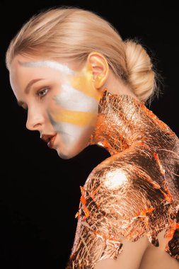 Parlak makyaj ve boynundaki altın folyo ile korku veren genç kadın