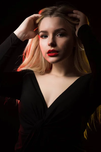 Модна молода жінка з червоними губами позує на темному фоні — стокове фото