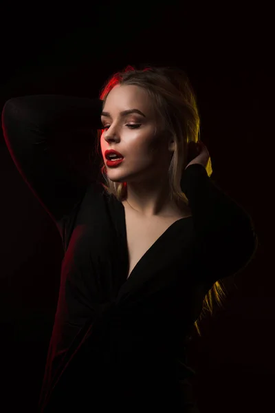 Модная молодая модель с ярким макияжем позирует поверх темной бабы — стоковое фото