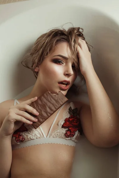 Sexy young woman in white bra with embroidery takes a bath with — Stock Photo, Image