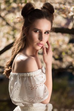 Çiçek açan Manolya ağacının yanında poz baştan çıkarıcı esmer kız