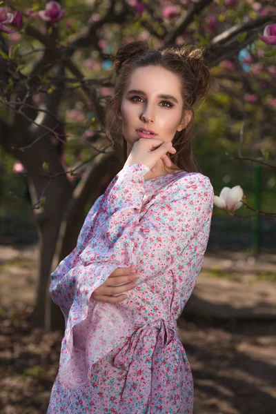 Mooie brunette meisje in de buurt van de bloeiende magnoliaboom ik poseren — Stockfoto