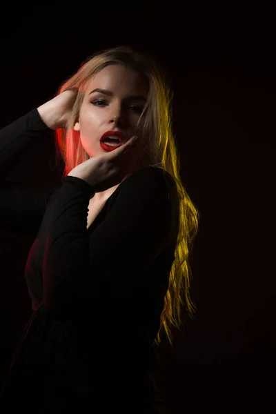 Modelo bastante joven con maquillaje brillante posando sobre un backgro oscuro —  Fotos de Stock