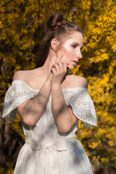 Güzel esmer kız beyaz La çiçeklenme tree yakınındaki poz