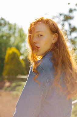 İhale Kızıl saçlı genç modeli Street güneş ışınlarının poz kot gömlek