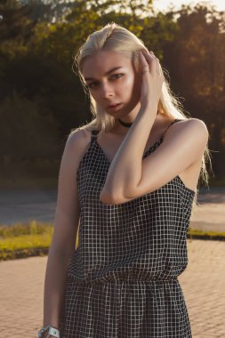 Siyah romper, güneş ışınlarının şehirde poz çekici sarışın kadın