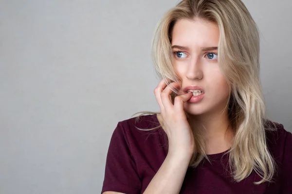 Vrij bang meisje poseren over een grijze achtergrond — Stockfoto