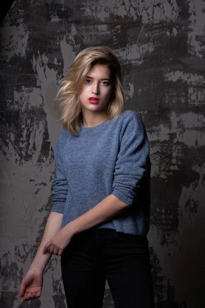 Fashionable girl wearing knit sweater posing in studio — Stock Photo, Image