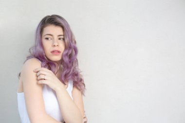Gri bir duvarın üzerinde duran yalnız kız