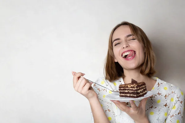 Merry girl eats yummy cake — Stock Photo, Image