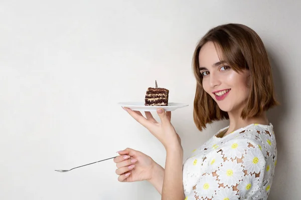 Merry girl eats yummy cake — Stock Photo, Image