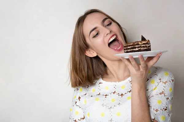 Tevreden meisje bijt lekker taart — Stockfoto