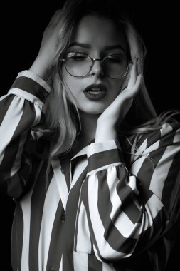 Muhteşem bir kadının dramatik portresi gölgede poz veren gözlükler takıyor. Siyah ve beyaz renk