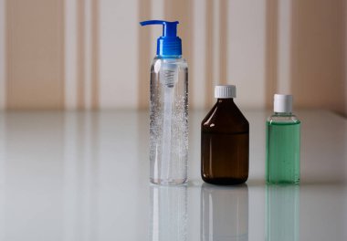 El hijyeni ve korona virüsü koruması için içinde antiseptik jel ve alkol bulunan şişeler. Tex için boşluk