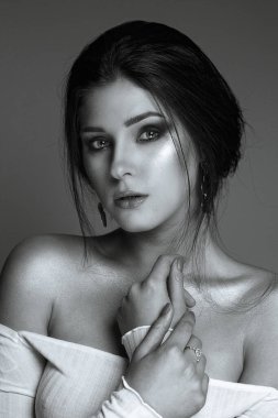 Parlak ciltli ve çıplak omuzları olan çekici esmer kadının stüdyo portresi. Monokrom rengi