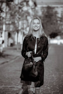 Neşeli sarışın kadının güneşli bahar portresi. Sıcak havanın tadını çıkarıyor, sokakta yürüyor. Tek renkli tonlama