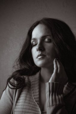 Uzun saçlı, gölgede poz veren çarpıcı şehvetli bir kadın portresi. Tek renkli tonlama