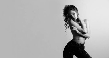 Siyah beyaz, kıvırcık saçlı, çıplak omuzlu, şehvetli bir genç kadın portresi. Metin için boşluk