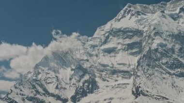Muazzam manzara, karlı devasa dağ Annapurna Ii 'nin sert yüzü bulutlarla kaplı.