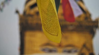 Bayraklar sallanıyor, bulanık Buda 'nın gözleri Swayambhunath tapınağındaki altın sallantıda. 