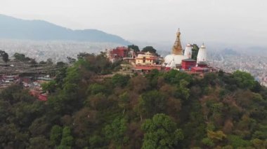 Hava manzarası. Swayambhunath Budist tapınağı, yeşil tepede, sisli Katmandu 'da