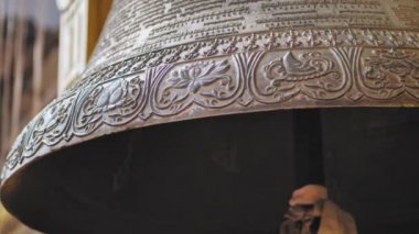 Boudhanath yakınlarında asılı kocaman metal çan, oymalı antika desenler, harfler.