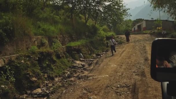 Besisahar, Nepal - Circa, 2019：Nepali boy run along roadside and waving hands — 图库视频影像