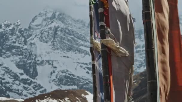 Terrific flags flap against cloudy frozen snow wall of Annapurna III mountain — Stock Video