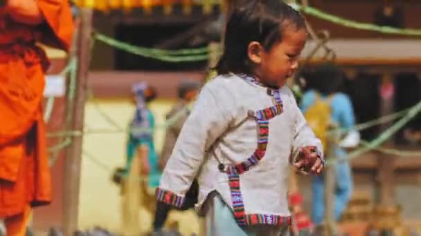 Kathmandu, Nepal - Circa, 2019: Kleine lachende nepali-jongen achtervolgt vogels op straat — Stockvideo