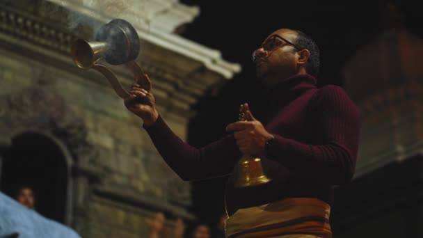 КАТХМАНДУ, НЕПАЛ - CIRCA, 2019: индуистский жрец в Пашупатинатх Аарти Багмати Пуджа — стоковое видео