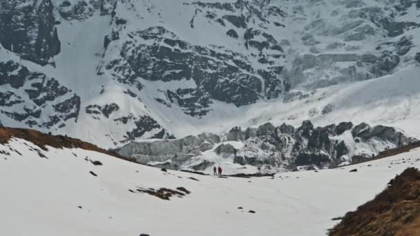 Touristen stehen in der Nähe von riesigen Gletscher am Fuße des Schnees annapurna iii Berg, Nepal — Stockvideo